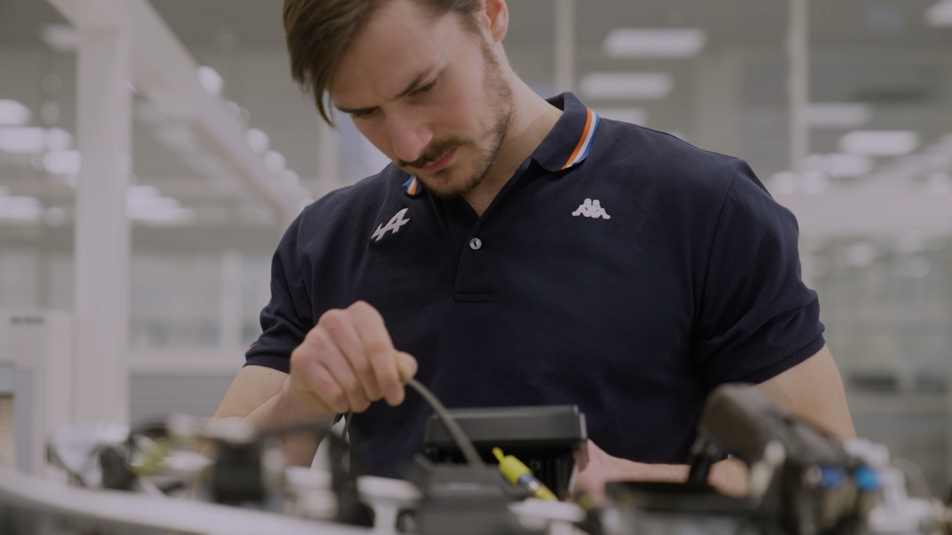 Ingénieur de chez Alpine travaillant sur un moteur
